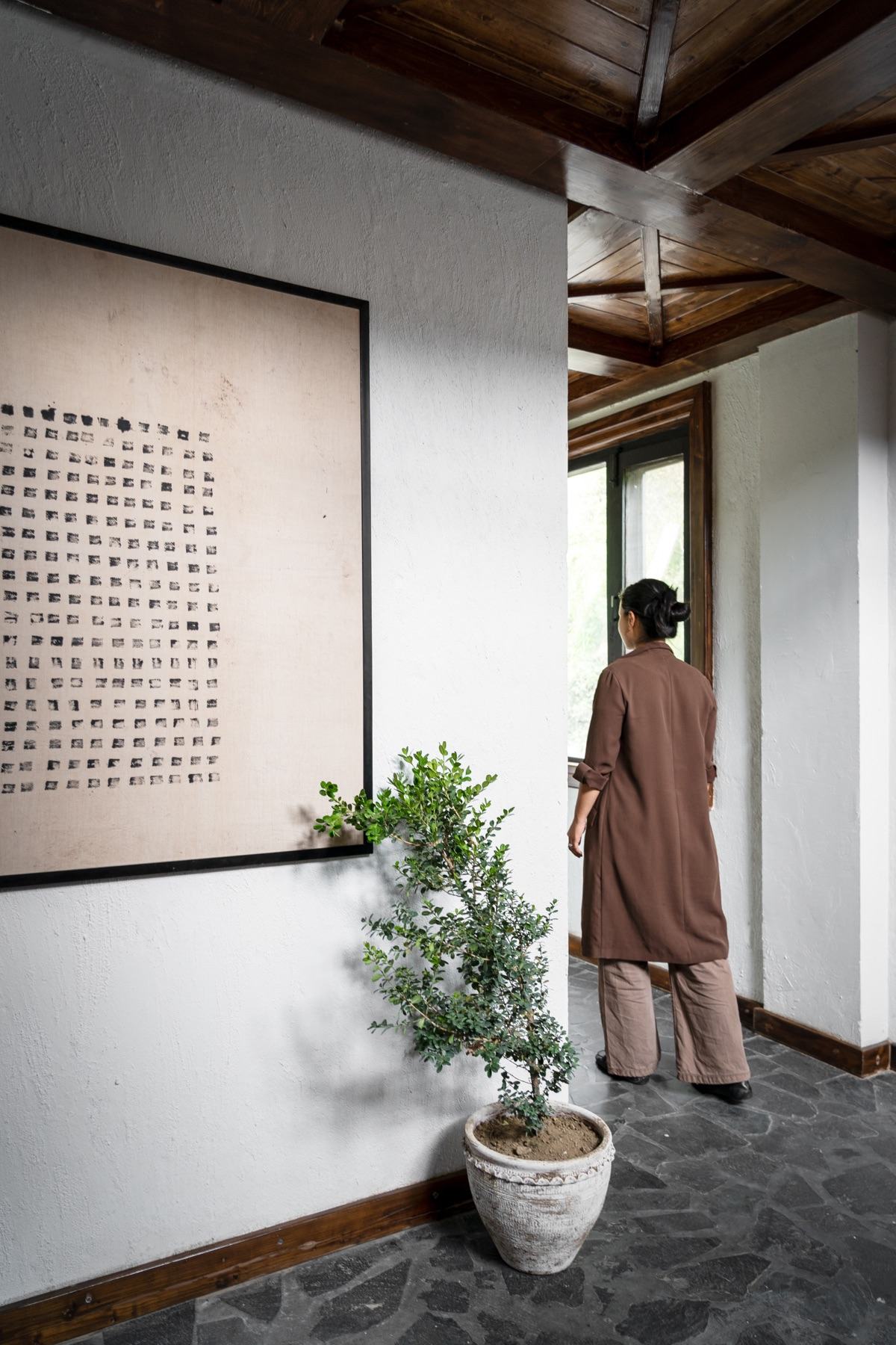 Guest walking past framed art at Ark Hunzuru