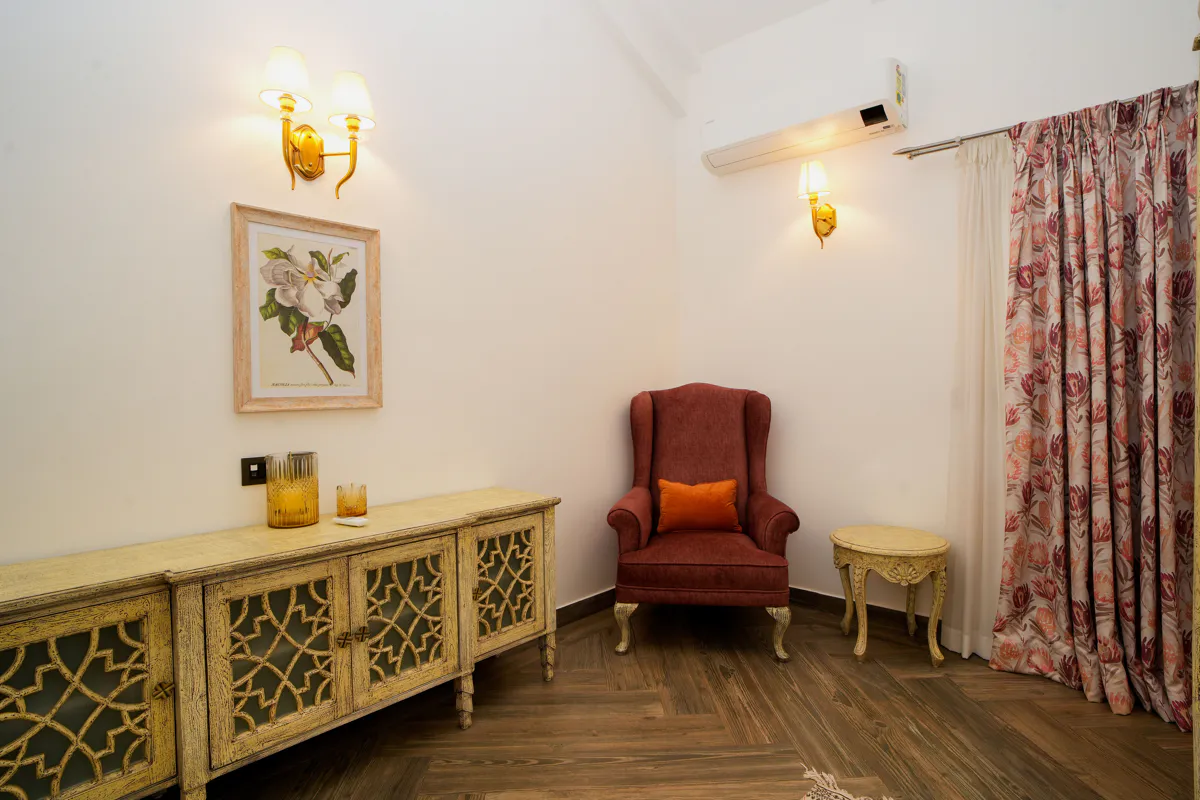 Carved console, wing chair and framed botanical print